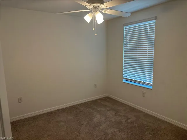 Empty room with ceiling fan and carpet flooring