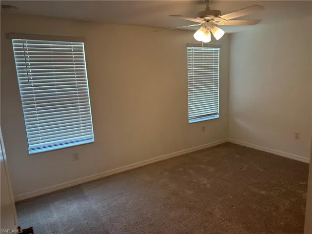 Carpeted empty room with ceiling fan