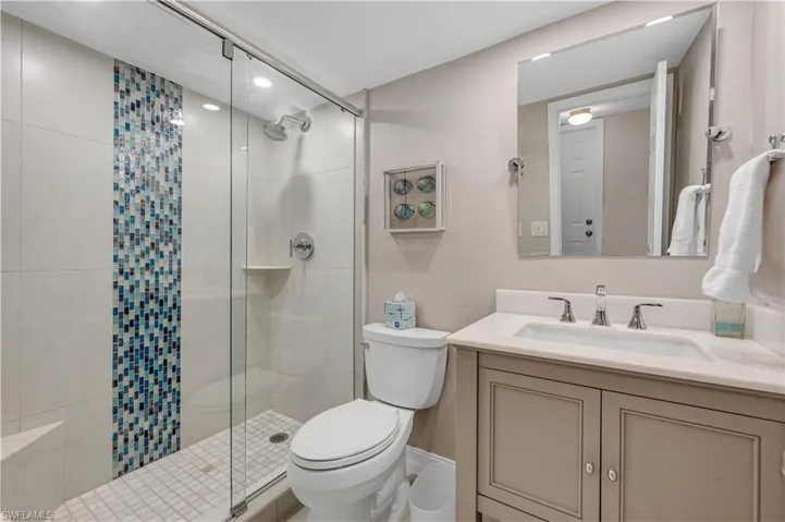 Full bath featuring a shower stall and vanity