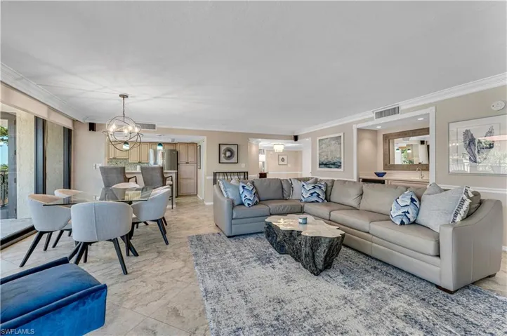 Living room featuring crown molding and a chandelier