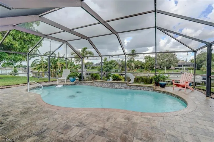 View of pool featuring a lanai, a water view, and a patio area