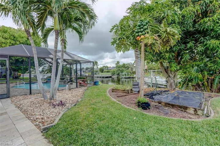 View of yard with a water view, a patio, and glass enclosure