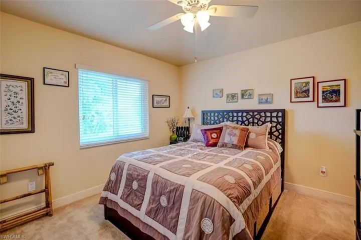Carpeted bedroom featuring ceiling fan