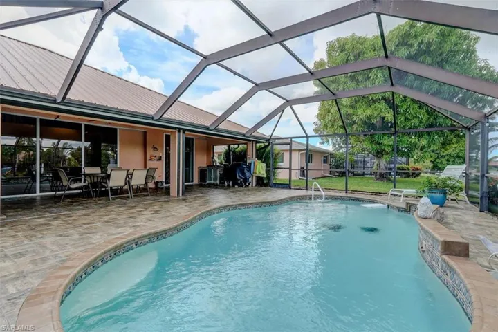 View of pool featuring a patio, a lawn, and a lanai
