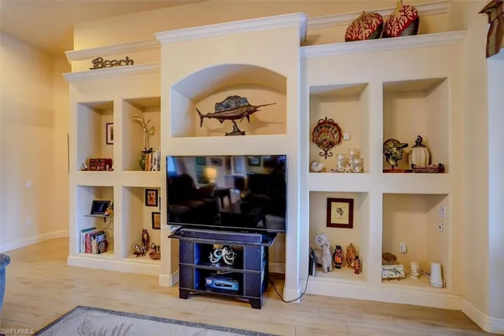Living room with wood-type flooring and built in shelves