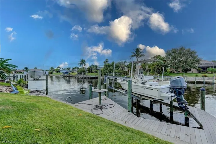 Dock area featuring a lawn and a water view