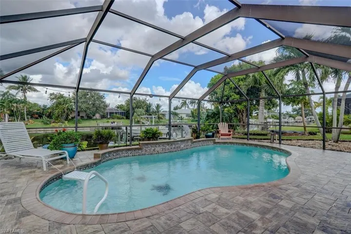 View of swimming pool featuring a patio and a lanai