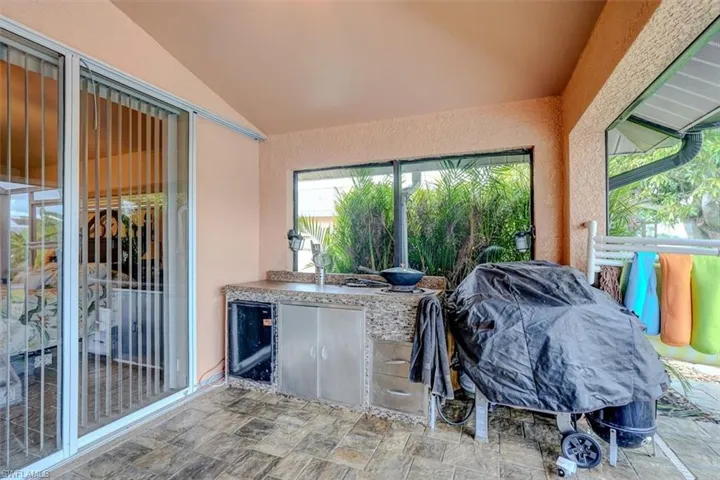 Sunroom / solarium featuring wine cooler and vaulted ceiling