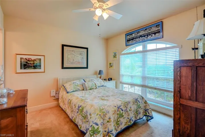 Front spare Bedroom with ceiling fan and light carpet