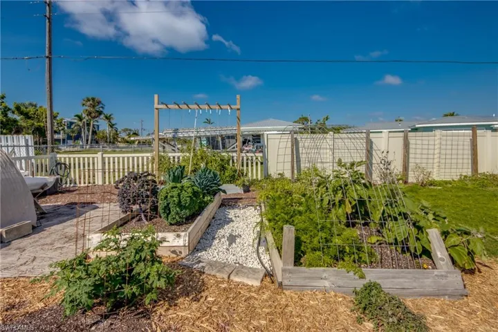 Fenced backyard featuring a vegetable garden
