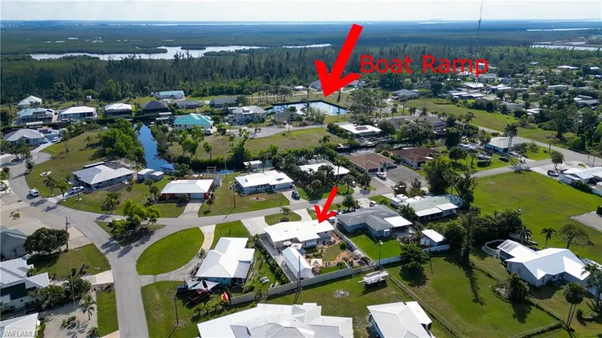 Aerial view of property and surrounding area with a nearby body of water and nearby suburban area