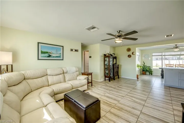 Living room featuring ceiling fan and baseboards
