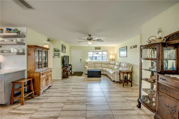 Living room with ceiling fan and light tile patterned floors