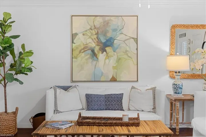 Living room with wood finished floors, crown molding, and baseboards