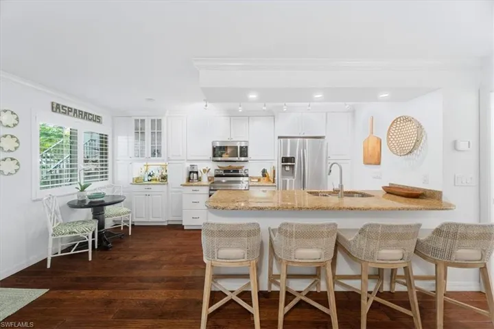 Kitchen featuring ornamental molding, a breakfast bar area, stainless steel appliances, and a sink