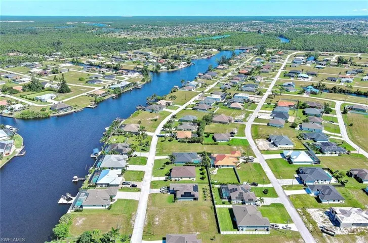 Aerial view of property's location with nearby suburban area and a nearby body of water