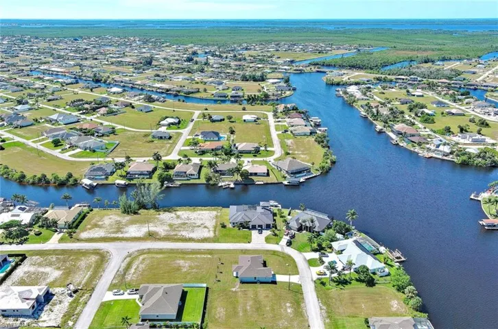 Aerial view of property's location with a large body of water and nearby suburban area
