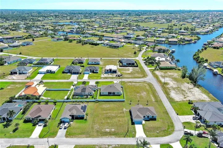 Aerial perspective of suburban area featuring a nearby body of water