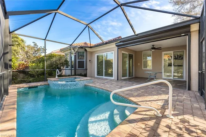 Combined pool / hot tub featuring a sunroom, glass enclosure, and a patio
