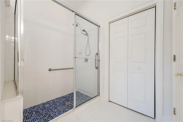 Full bathroom with a closet, a stall shower, and light tile patterned floors