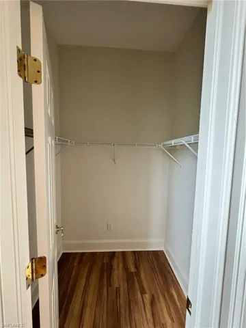 Walk in closet featuring dark wood-type flooring
