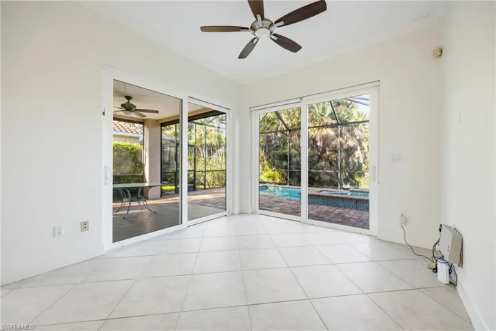 Unfurnished room with a sunroom, ceiling fan, crown molding, healthy amount of natural light, and light tile patterned floors