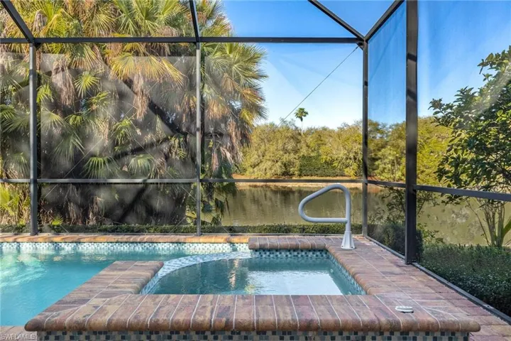 Integrated pool / spa with a lanai, a sunroom, and a water view