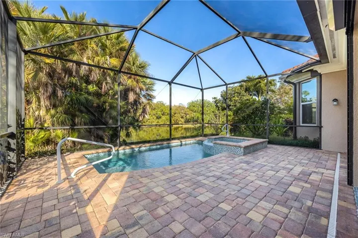 Combined pool / hot tub featuring a sunroom, a patio area, and a lanai