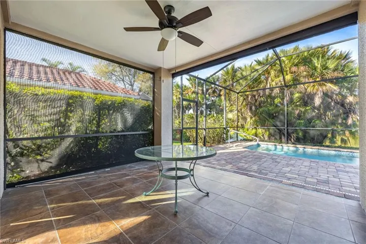 Unfurnished sunroom with a patio and ceiling fan