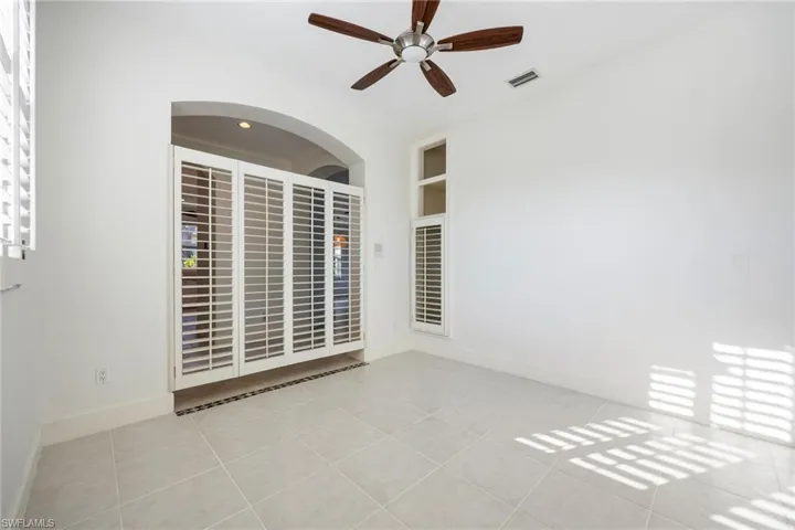 Spare room with ceiling fan, light tile patterned floors, and built in features