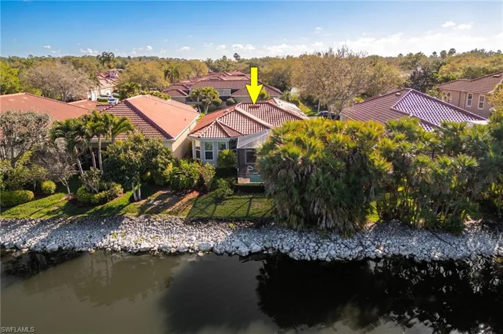 Drone / aerial view of a nearby body of water and a tree filled landscape