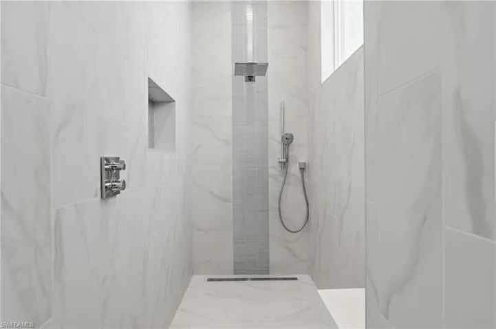 Full bath with a marble finish shower