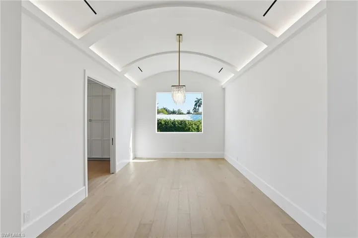 Unfurnished dining area featuring a barrel ceiling and light wood-type flooring