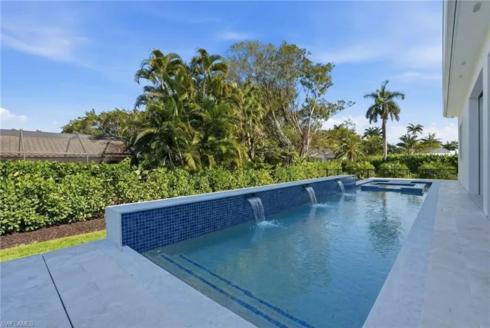 Integrated pool / hot tub featuring a fenced backyard and a patio area