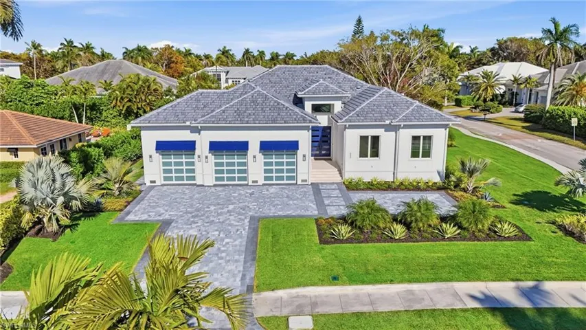 View of front of house with a front lawn, an attached garage, and stucco siding
