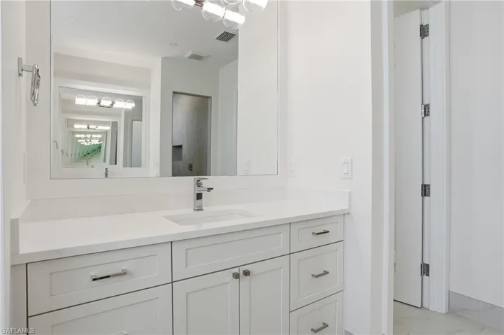 Bathroom featuring vanity and light marble finish floors