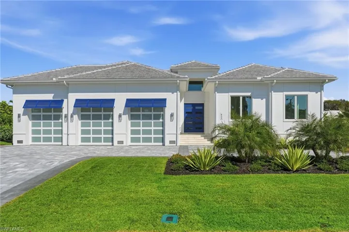 View of front of home featuring a front yard, decorative driveway, and stucco siding