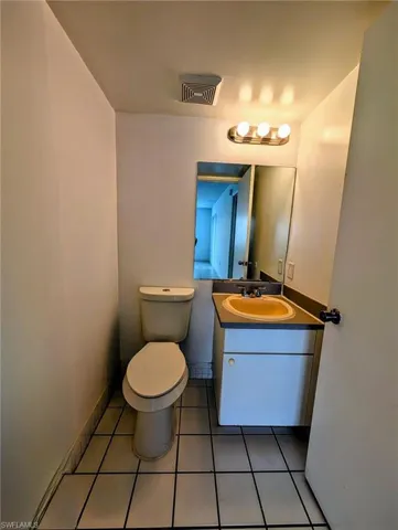 Half bath featuring vanity and light tile patterned floors