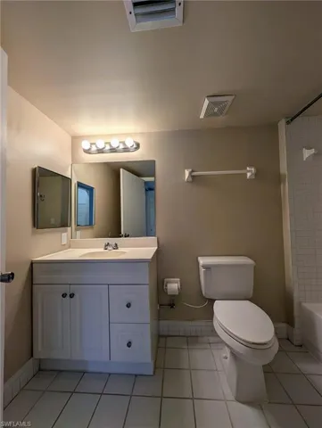 Bathroom with light tile patterned floors, vanity, and bathtub / shower combination