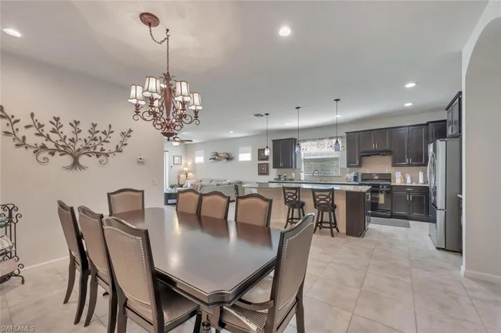 Dining area featuring light tile patterned floors, recessed lighting, and a chandelier