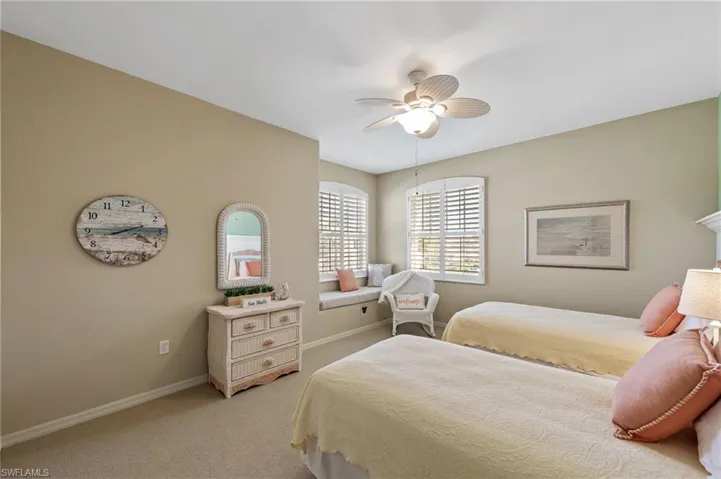 One of the guest bedrooms with a quaint corner window space for reading