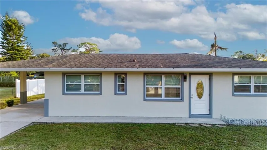Single story home featuring stucco siding and a carport