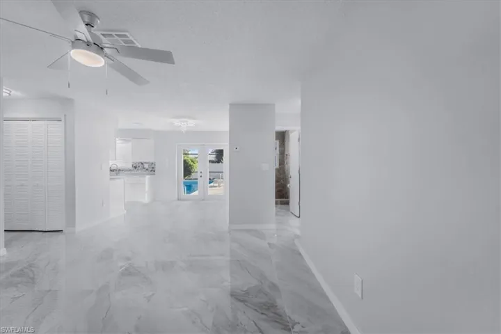 Spare room with light marble finish floors, a textured ceiling, and ceiling fan