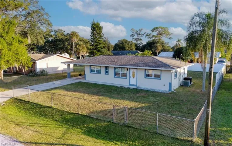 View of front of home with stucco siding, a carport, a fenced backyard, and concrete driveway