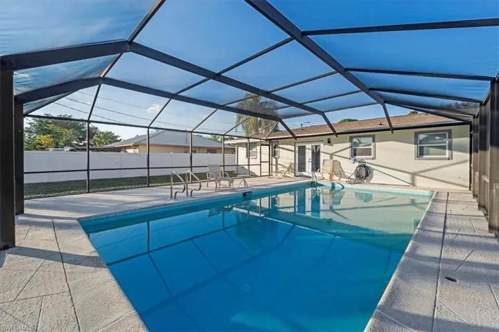 View of swimming pool with a lanai, a sunroom, and a patio area