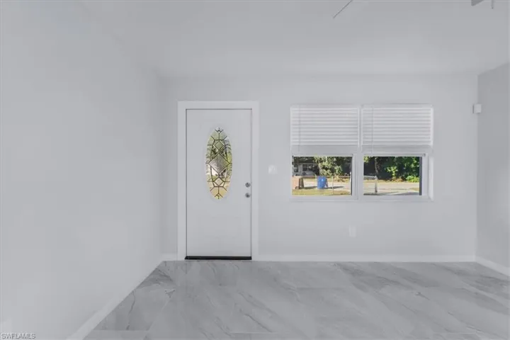 Entrance foyer with light marble finish floors and baseboards