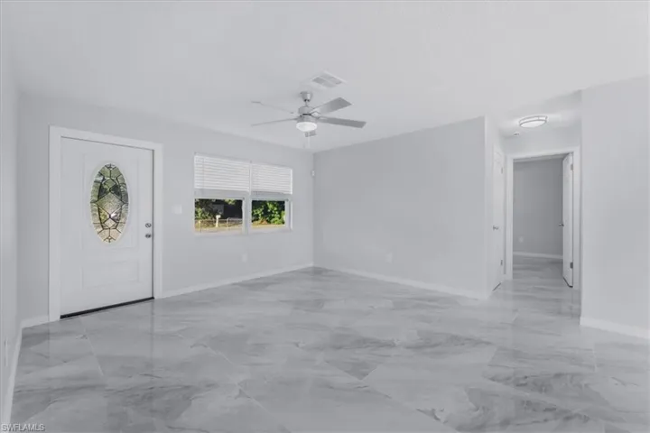 Entryway featuring light marble finish flooring and ceiling fan