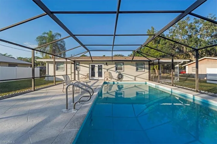 Swimming pool featuring a sunroom, a lanai, and a patio area