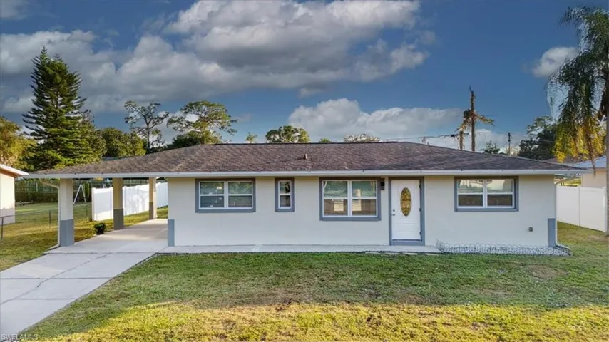 Single story home featuring a carport, stucco siding, and concrete driveway