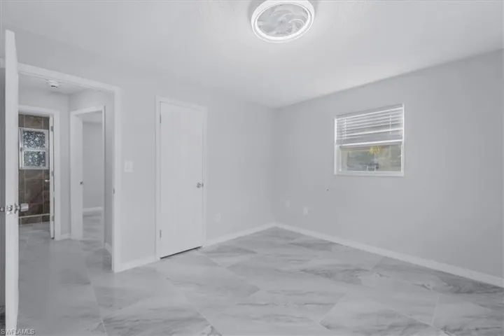 Spare room with light marble finish floors and a textured ceiling